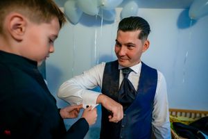 An emotional moment shared between two people at a formal event with blue balloon decorations.