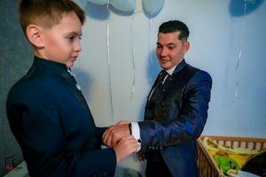 Two people in formal wear share a lighthearted moment together.
