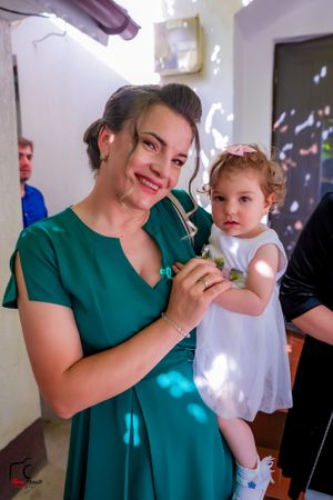 A bridesmaid in emerald green helps with wedding day preparations.