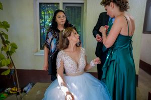 Natural light streams through windows as wedding party helps prepare the bride for her special day.