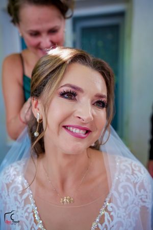 Bride in an elegant white gown showing playful expressions during wedding photography session.