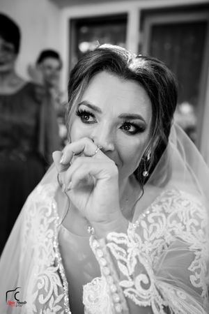 Black and white photo of bride showing emotional moment during wedding preparations.
