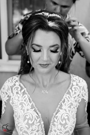 Close-up portrait of a bride wearing an elegant white lace wedding dress with delicate embroidery details.