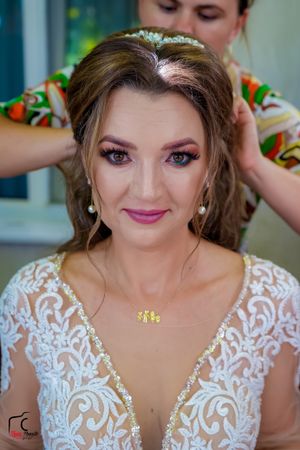 Bridal preparation photo showing intricate lace dress and professional hair and makeup.