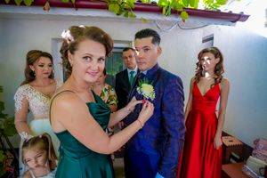 Wedding party members interacting during pre-ceremony preparations in a bright indoor space.