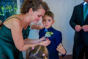 Intimate wedding moment showing final touches being made to formal attire.