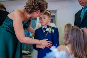 Wedding party members sharing a sweet interaction while fixing formal wear details.