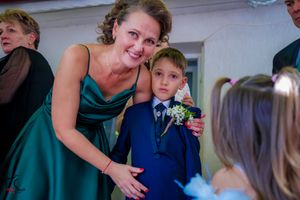 Close-up of a caring moment during wedding preparations with formal attire adjustments.