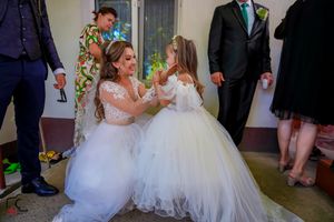 A heartwarming dance moment between two people wearing matching white tulle gowns.