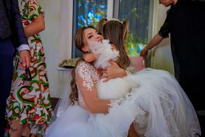 Emotional wedding day moments captured between family members in formal attire.