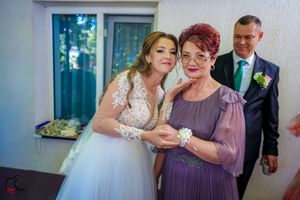 Wedding party members share intimate moments in an indoor venue with natural lighting.