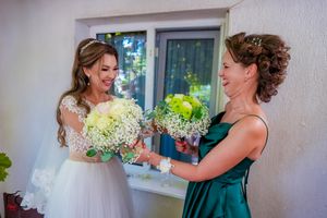 Candid wedding party moments captured against white wall with window.