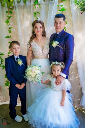 Wedding portrait featuring formal attire and white floral bouquet under garden setting.