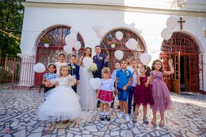 Outdoor wedding photography session with church architecture and stone pavement.