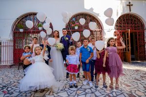 Wedding group photos being taken outside church with distinctive stone flooring.