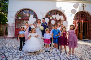 Wedding celebration with guests in formal attire outside church entrance.