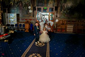 Dimly lit ballroom with ornate decor and blue carpeting during a wedding celebration.