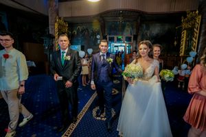 Guests mingle during a wedding reception in a ballroom with elegant decor and lighting.
