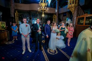 A couple shares an intimate moment during their wedding ceremony in an ornately decorated church.