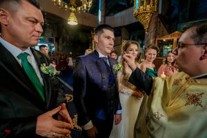 Wedding guests gather in a dimly lit venue with decorative lighting and festive atmosphere.
