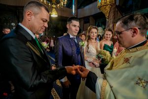 Wedding celebration scene with guests mingling in atmospheric lighting.
