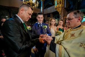 Indoor wedding reception with guests gathered in formal attire.