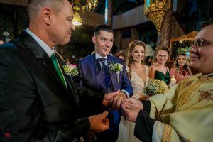 Candid reception moment with guests in formal wear and yellow ambient lighting.