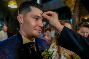 Intimate moment captured during wedding reception with soft yellow lighting.