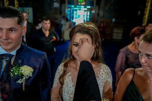 Wedding party gathered at an indoor reception venue with decorative lighting and floral arrangements.