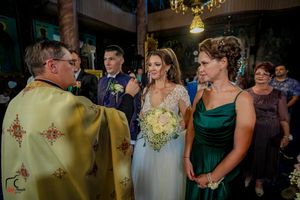 Evening wedding reception with guests in formal attire under decorative lighting.