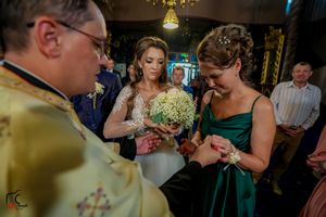 Indoor wedding reception scene with decorative lighting and guests in formal wear.