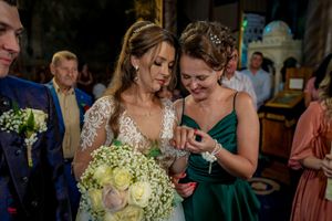 Wedding celebration featuring elegant dresses and a stunning white rose bouquet.