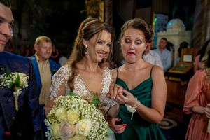 Candid moment at a wedding showing reactions and emotions with floral bouquet.