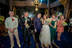 Bridal party gathered in church interior featuring blue carpet and golden architectural details.
