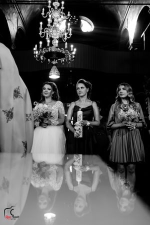 Elegant black and white photo of wedding party under crystal chandelier in church.