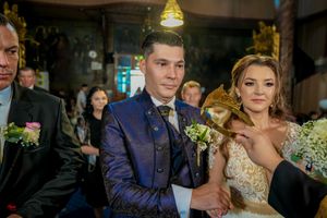 Wedding party watches attentively during Orthodox church ceremony.