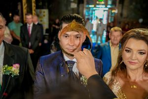 Wedding couple wearing ceremonial crowns during Orthodox marriage ritual.