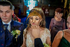 Wedding guests show emotional expressions during ceremony in dimly lit church.
