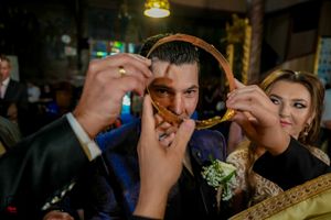Traditional Orthodox wedding ceremony with ceremonial crown being adjusted in warm lighting.