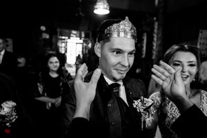 Wedding celebration captured in dramatic black and white with guests celebrating in dark venue.