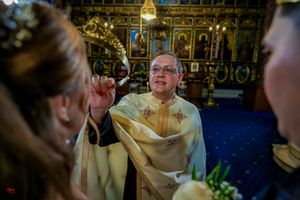 Religious ceremony in progress within traditionally decorated Orthodox church setting.
