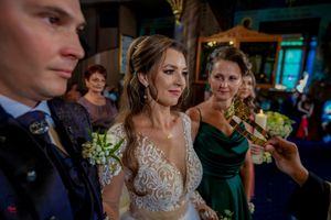 Interior of Orthodox church during wedding ceremony with iconic religious artwork.