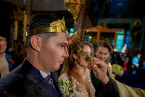 Candlelit church ceremony with golden religious icons and decorative elements.