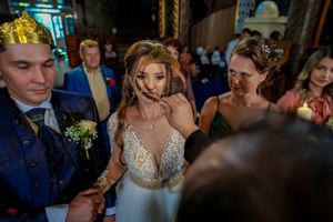 Wedding guests gathered in a beautifully decorated Orthodox church during ceremony.