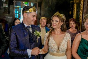 Elegant wedding reception with guests in formal attire and decorative lighting.