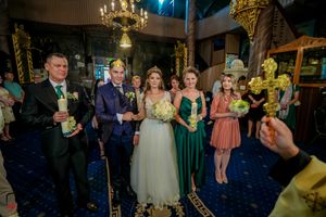 Wedding party gathered in elegant venue with chandelier and festive atmosphere.