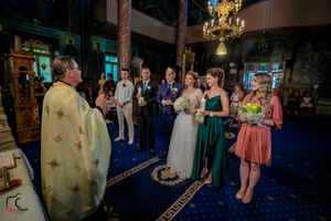 Panoramic view of wedding guests gathered in elegant ballroom with blue accent lighting and formal decor.