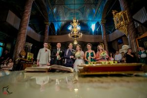 Panoramic view of wedding reception with guests gathered in ornate hall with blue accent lighting.