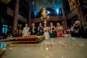 Wide angle shot of wedding party in ornate venue with dramatic lighting and fog effects.