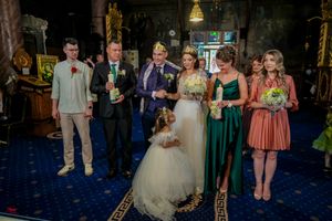 Wedding party lineup in formal attire standing on decorative blue carpet.